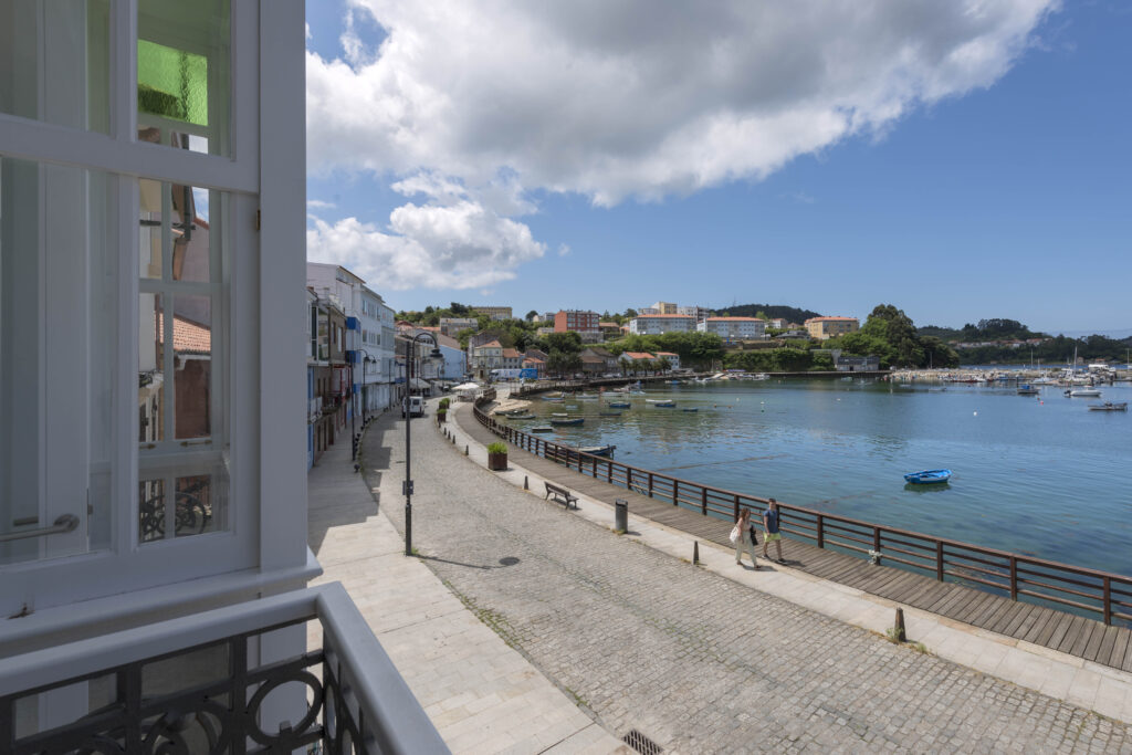 Vista del paseo, el mar de mugardos y sus botes desde un balcón